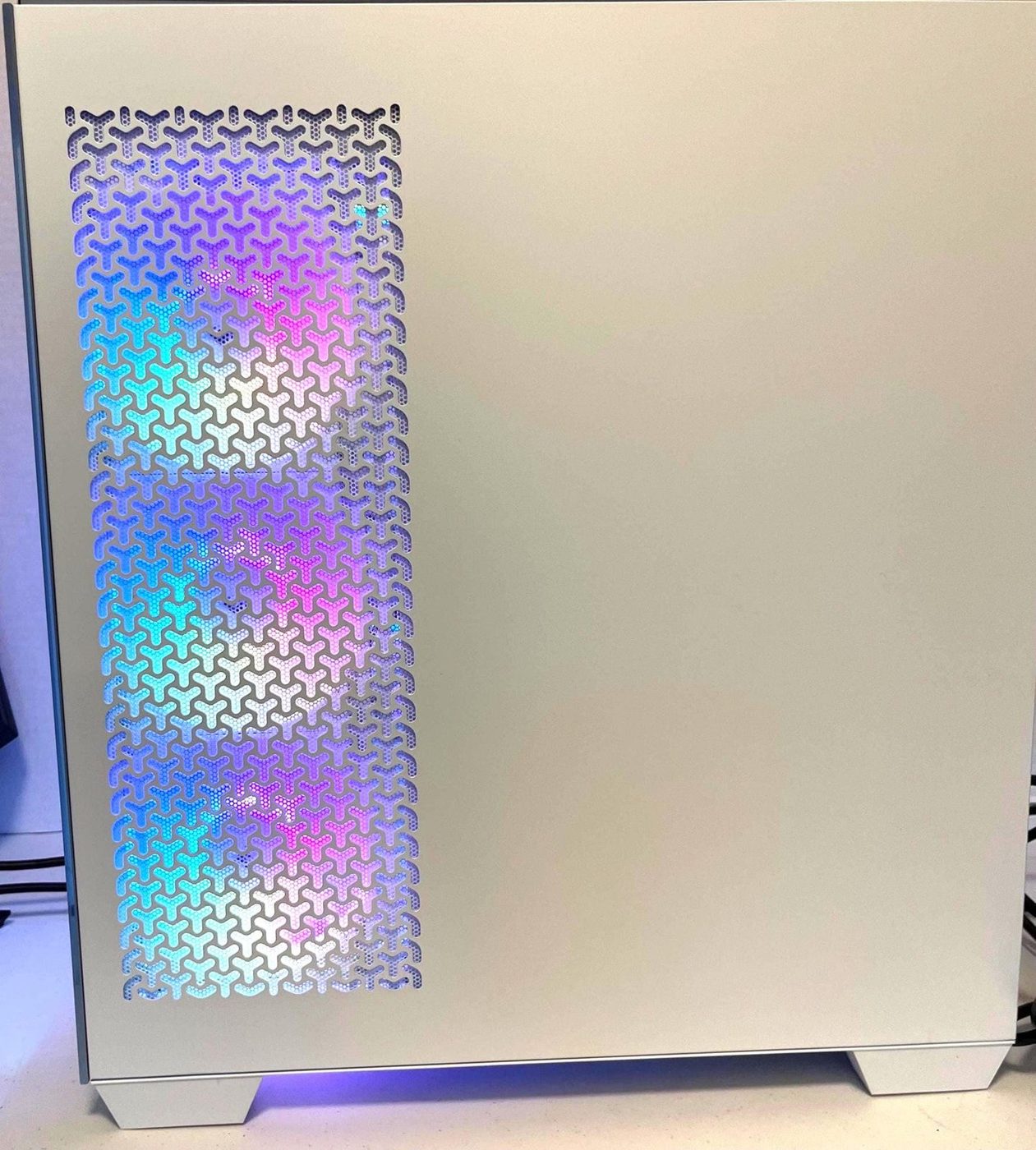 Side panel of a white Corsair gaming PC glowing with RGB light